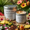 Sandy Lee Candles Tropical Punch candle with packaging, surrounded by tropical fruits and flowers.