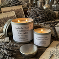 Two lit candles in 'Weathered Lavender' by Sandy Lee Candles on a rustic wooden surface with lavender and vintage items.